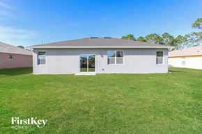 Palm Bay house for rent - a white house with a grassy yard and a blue sky