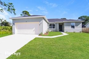 Palm Bay house for rent - a white house with a lawn and a garage door