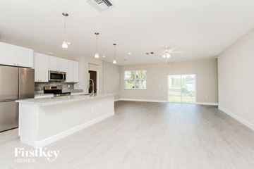 Palm Bay house for rent - an open kitchen and living room with white cabinets and a white counter top