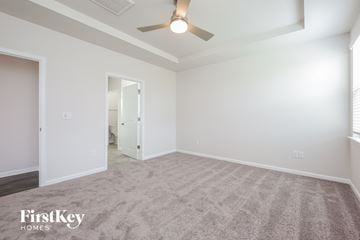 Greenville house for rent - a spacious living room with carpet and a ceiling fan