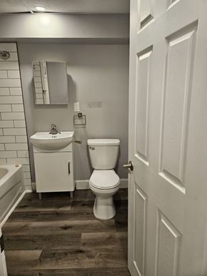 London apartment for rent - A white toilet sits next to a white sink in a small bathroom.