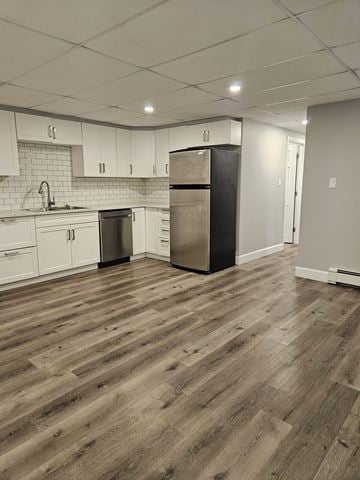 London apartment for rent - A kitchen with wooden floors and white cabinets.