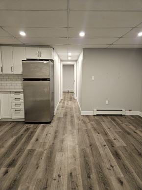 London apartment for rent - A long hallway with a stainless steel refrigerator on the left.