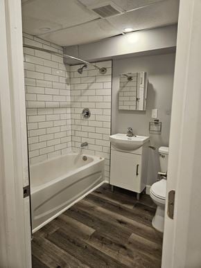 London apartment for rent - A white bathroom with a wooden floor and a white tub.