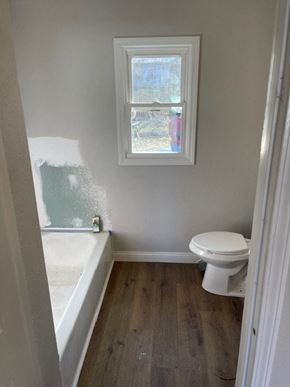Clinton house for rent - a bathroom with a toilet and a tub and a window