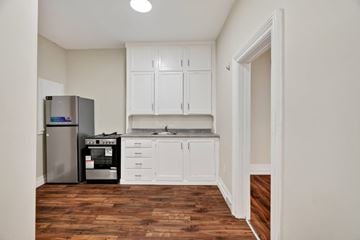 London apartment for rent - A kitchen with white cabinets and a stainless steel refrigerator.