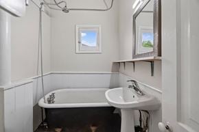 London apartment for rent - A white sink is in a bathroom with a black tub.