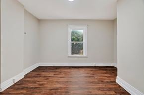London apartment for rent - A room with a window and wooden floors.