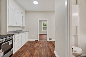 London apartment for rent - A kitchen with white cabinets and a black stove top oven.