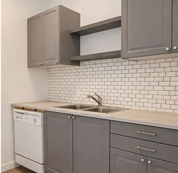 London apartment for rent - A kitchen with grey cabinets and a white dishwasher.
