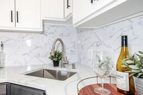 Washington apartment for rent - a white marble kitchen with a sink and bottle of wine