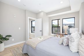 Washington apartment for rent - a master bedroom with a large bed and a window