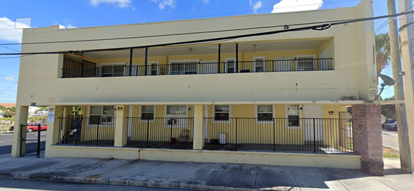 West Palm Beach apartment for rent - an old building with a fence and a street in front of it