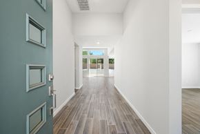 Desert Hot Springs house for rent - a hallway with white walls and wood floors and a blue door
