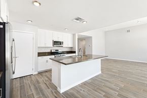 Desert Hot Springs house for rent - a large kitchen with white cabinets and a counter top