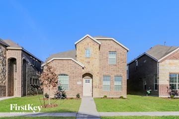 Fort Worth house for rent - side view of two story brick home with green grass and a blue sky