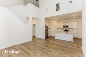 Fort Worth house for rent - a living room and kitchen with white walls and wood flooring