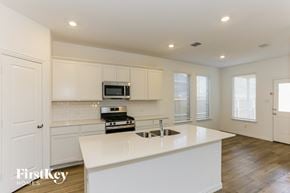 Fort Worth house for rent - a kitchen with white cabinets and a white counter top