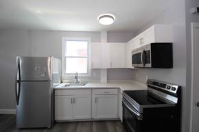 Philadelphia apartment for rent - A kitchen with a stainless steel refrigerator and black stove top oven.