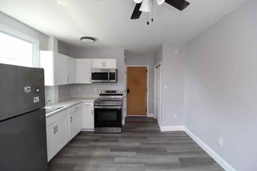 Philadelphia apartment for rent - A kitchen with white cabinets and a black fridge.