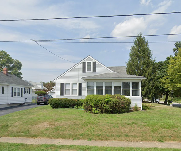 Wilmington house for rent - A house with a white exterior and a grey roof is surrounded by greenery.