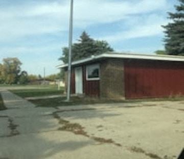 Carrington apartment for rent - a small building with a red fence next to a street