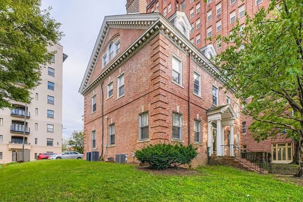 Baltimore apartment for rent - A red brick building with a white door and windows.