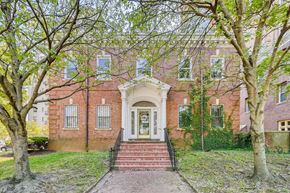 Baltimore apartment for rent - A red brick house with a white door and steps leading up to it.