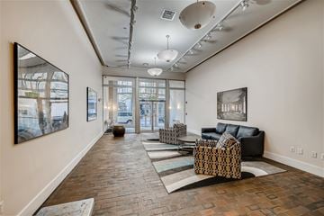 Baltimore apartment for rent - A living room with a black couch and a large painting on the wall.