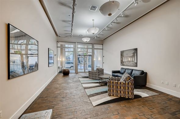 Baltimore apartment for rent - A living room with a black couch and a large painting on the wall.