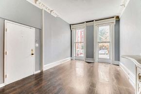 Baltimore apartment for rent - an empty living room with wood floors and a door