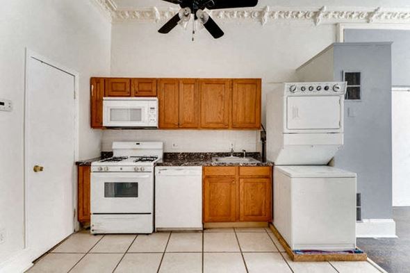 Baltimore apartment for rent - a kitchen with white appliances and wooden cabinets