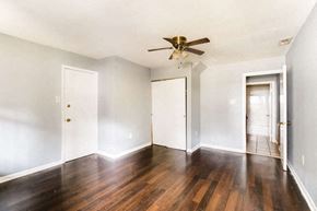 Baltimore apartment for rent - an empty living room with white walls and a ceiling fan