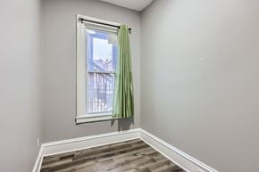 Baltimore apartment for rent - A room with a window and a green curtain.