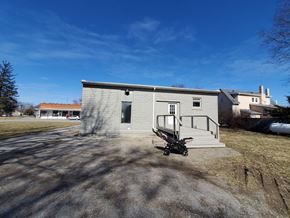 Vaughnsville apartment for rent - A small grey building with a black object in front of it.