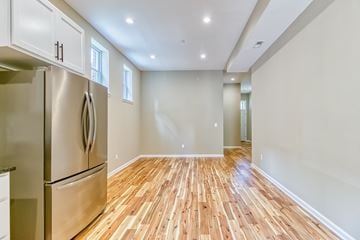 Baltimore apartment for rent - A kitchen with a stainless steel refrigerator and wooden flooring.