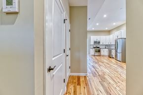 Baltimore apartment for rent - A white door is in a hallway with a wood floor.