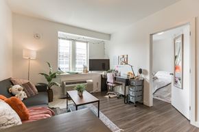 Philadelphia apartment for rent - A living room with a couch, a coffee table, and a bedroom with a bed and a desk.