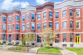 Baltimore apartment for rent - A red brick building with blue doors and windows.