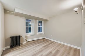 Baltimore apartment for rent - A room with a radiator and wooden flooring.