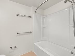 San Jose apartment for rent - A white bathroom with a tub, towel rack, and shower head.
