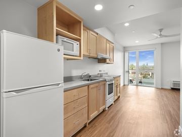 San Jose apartment for rent - A kitchen with wooden cabinets and a white refrigerator.