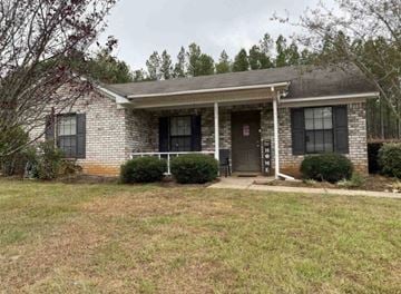Magee house for rent - A house with a front porch and a brown door.