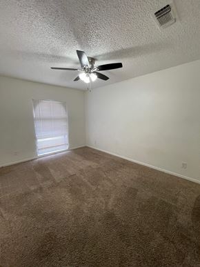 Killeen house for rent - an empty living room with a ceiling fan and a window