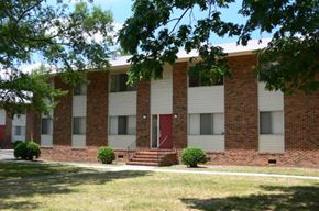Richmond apartment for rent - a brick and white building with a red door