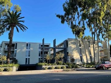 Pasadena apartment for rent - A modern building with a red car parked in front.