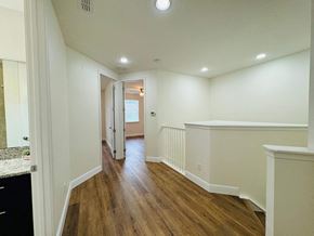 Orlando house for rent - a renovated living room and hallway with white walls and wood floors