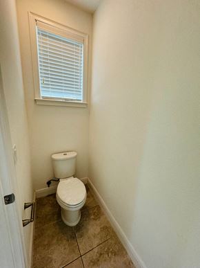 Orlando house for rent - a small bathroom with a toilet and a window