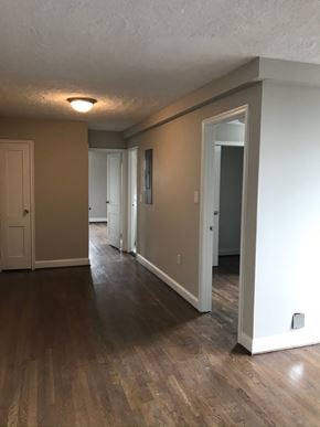 Washington apartment for rent - a living room and hallway with wood floors and white walls