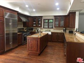 Los Angeles house for rent - a large kitchen with wooden cabinets and stainless steel appliances